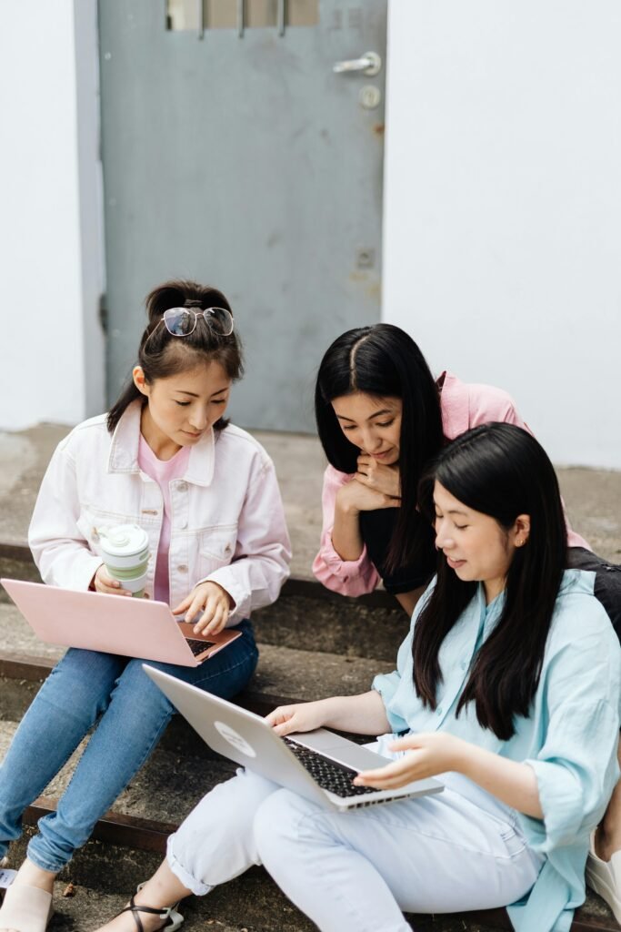 Three girls using used laptops